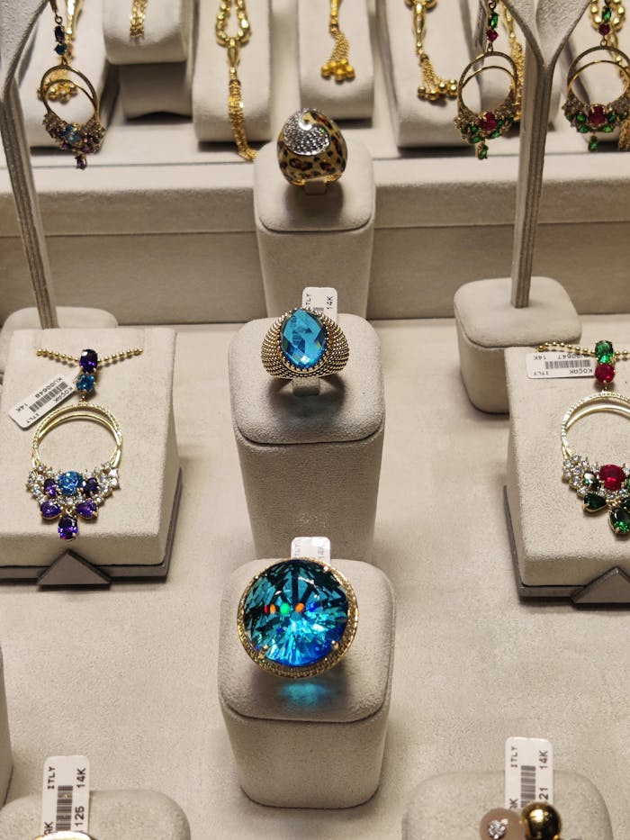 Showcasing a collection of exquisite luxury rings with gemstones in a display case.