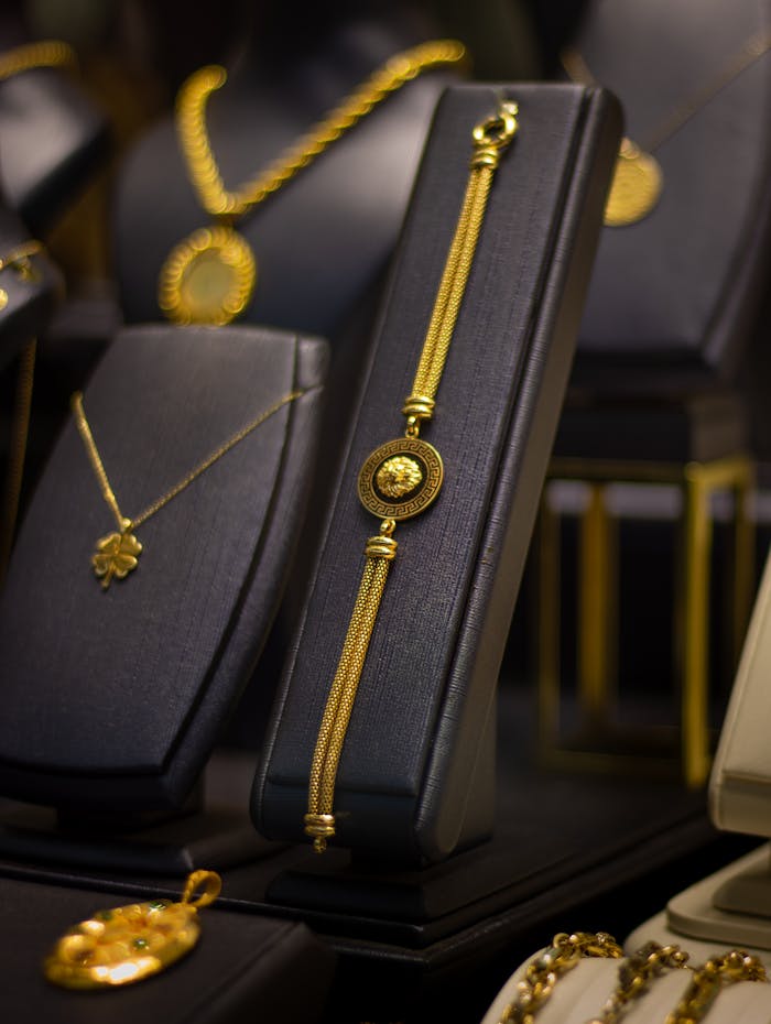Luxurious gold jewelry elegantly displayed on black stands in a jewelry store.