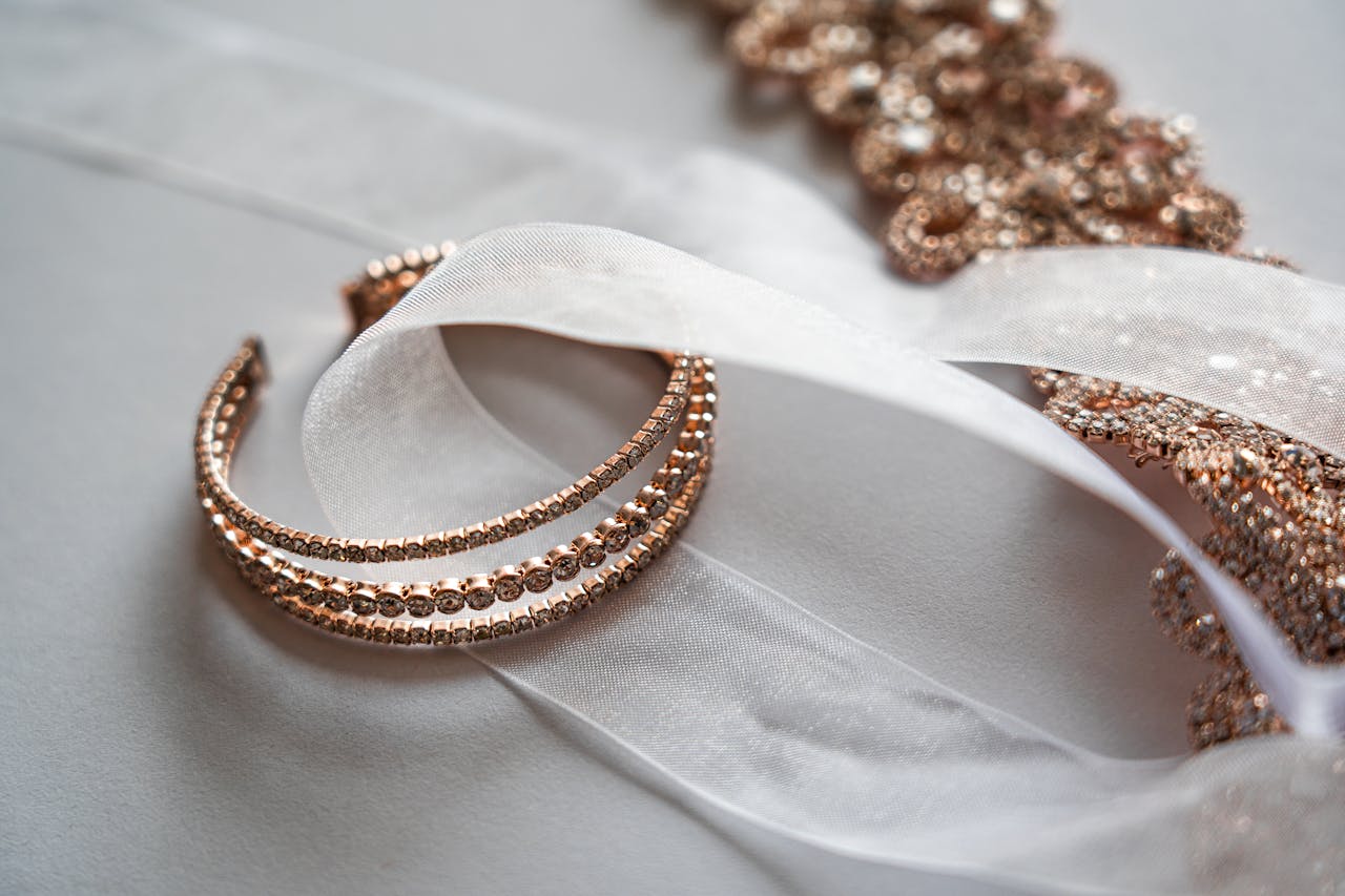 our-story Close-up of luxurious rose gold jewelry on a sheer satin fabric, perfect for bridal occasions.